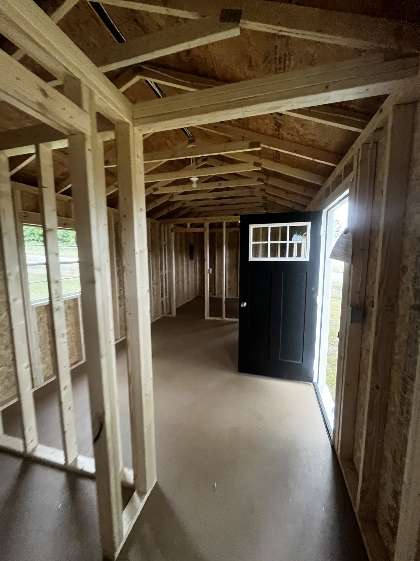 Outland Trailers 12x36 tiny home shell showing wooden exterior walls and door opening, ready for customization.