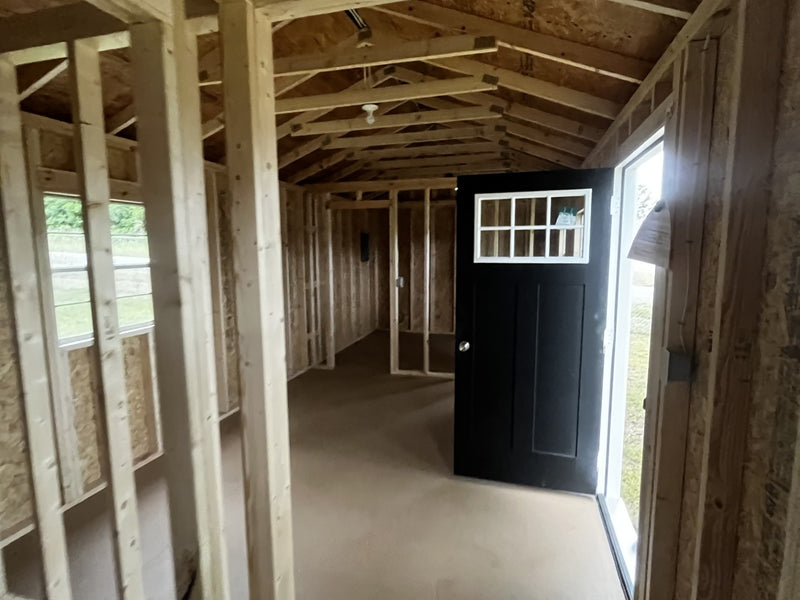 Outland Trailers 12x36 tiny home shell showing wooden exterior walls and door opening, ready for customization.