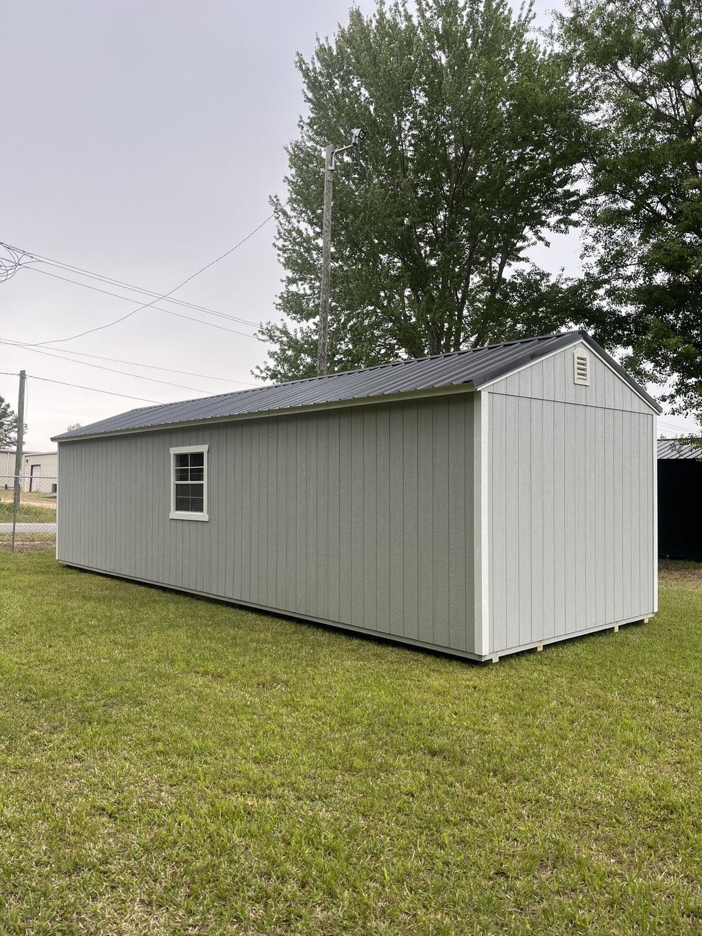 Outland Trailers 12x36 Tiny Home Shell with wooden exterior and window, ready for customization and interior finishing.