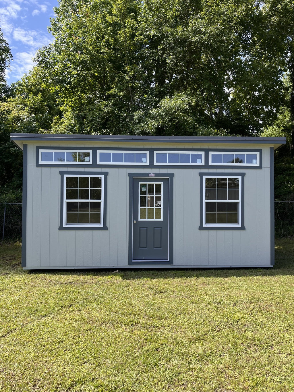 Outland Trailers 10x20 sloped studio trailer featuring a sleek, metal exterior with a sloped roof and large side door.