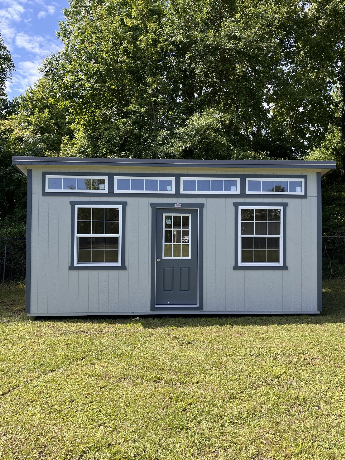 Outland Trailers 10x20 sloped studio trailer featuring a sleek, metal exterior with a sloped roof and large side door.