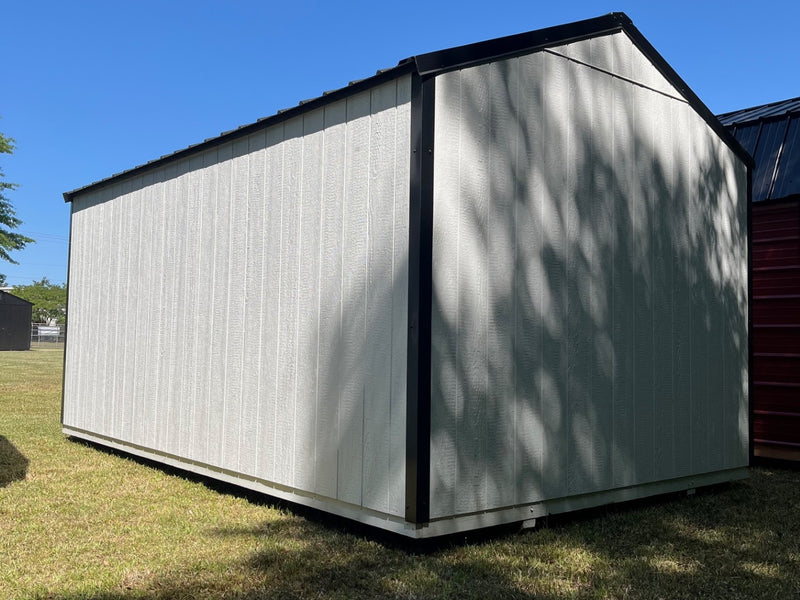 Outland Trailers 10x16 Tru-Valu Utility Shed with metal roof and double doors, placed on a grassy outdoor area.