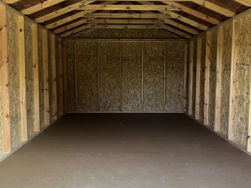 Outland Trailers 12x20 utility shed with metal walls and a single door, suitable for storage and outdoor use.
