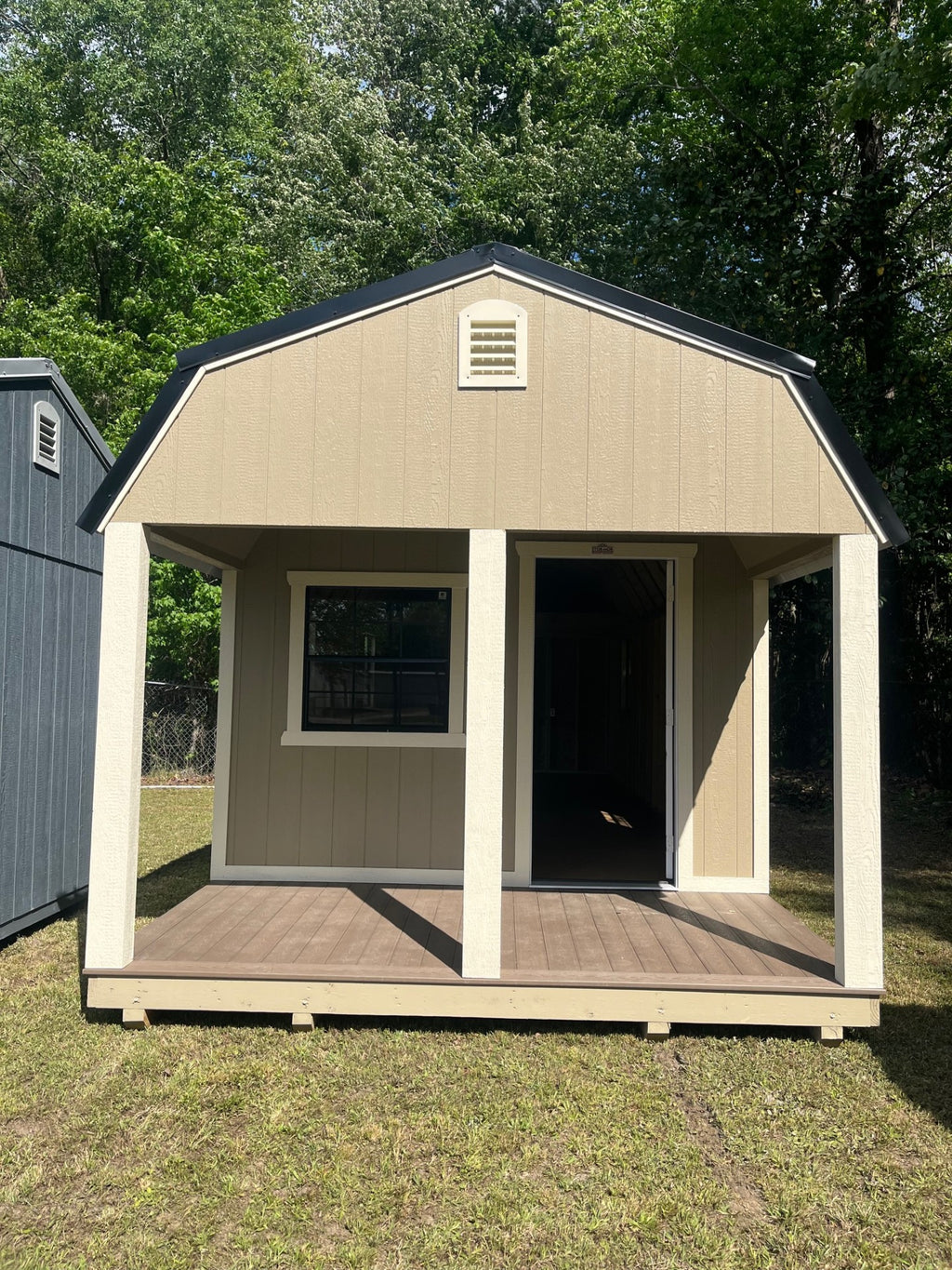 Outland Trailers 12x32 lofted barn cabin with wooden exterior, elevated design, and large front porch for outdoor relaxation.