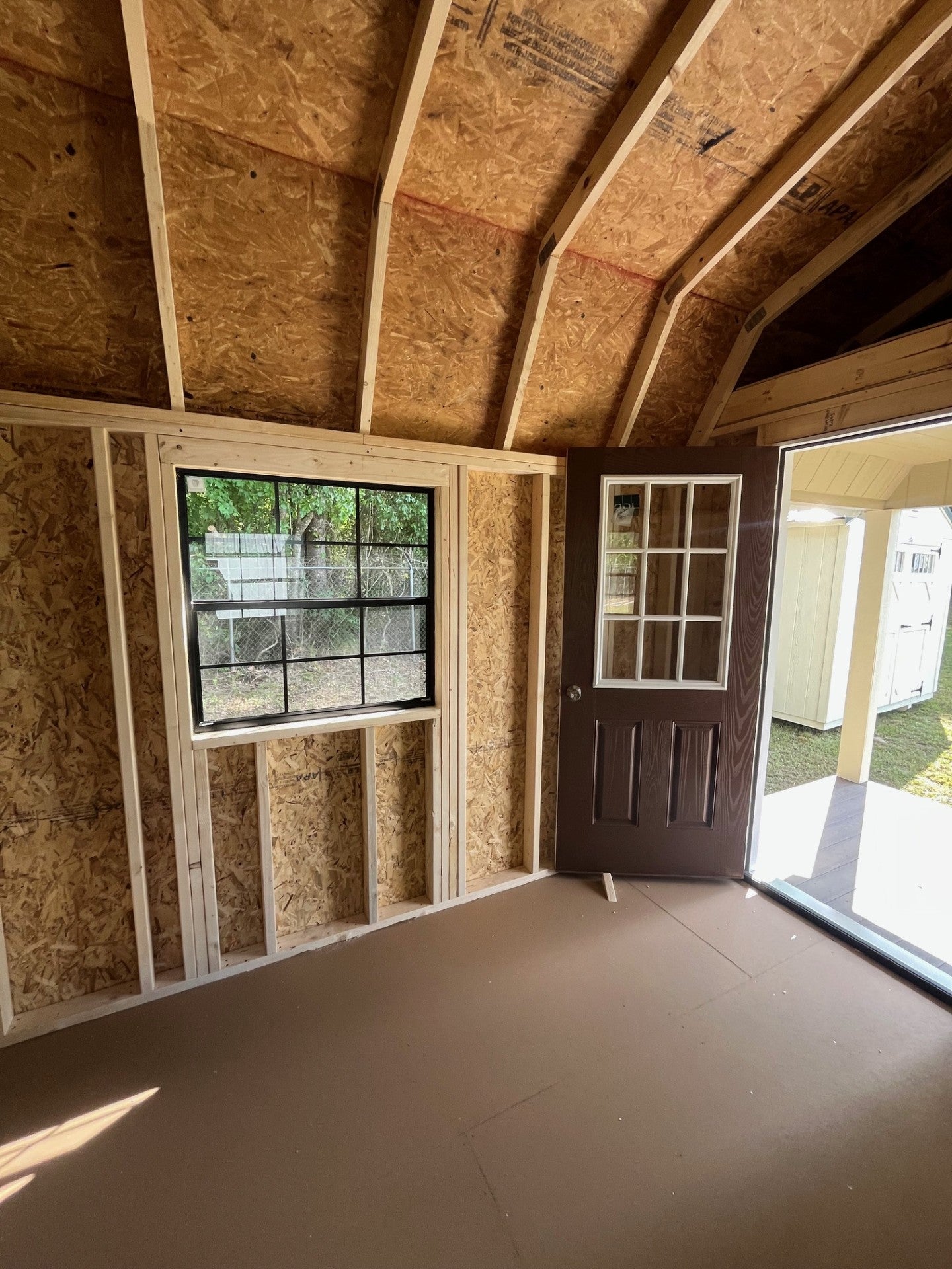 Outland Trailers 12x32 lofted barn cabin with elevated design, wooden exterior, and large windows for versatile outdoor living space.