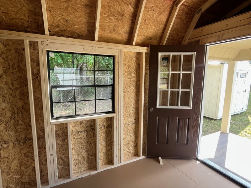 Outland Trailers 12x32 lofted barn cabin with elevated design, wooden exterior, and large windows for versatile outdoor living space.