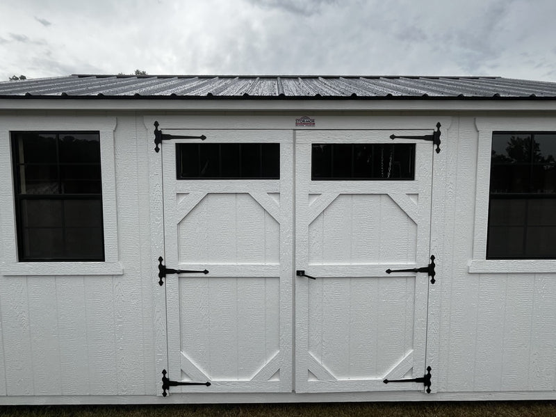 Outland Trailers 10x16 garden shed with durable metal walls and a gable roof, ideal for outdoor storage and gardening tools.