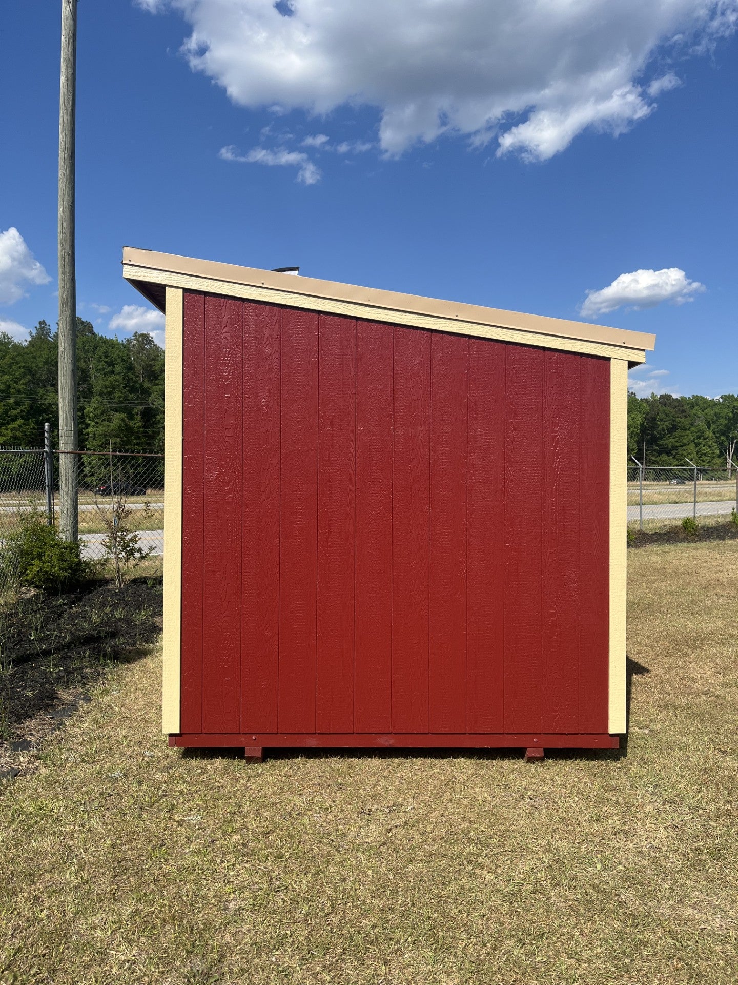 Outland Trailers 8x10 cottage shed with wooden exterior, gable roof, and double doors, ideal for storage or garden use.
