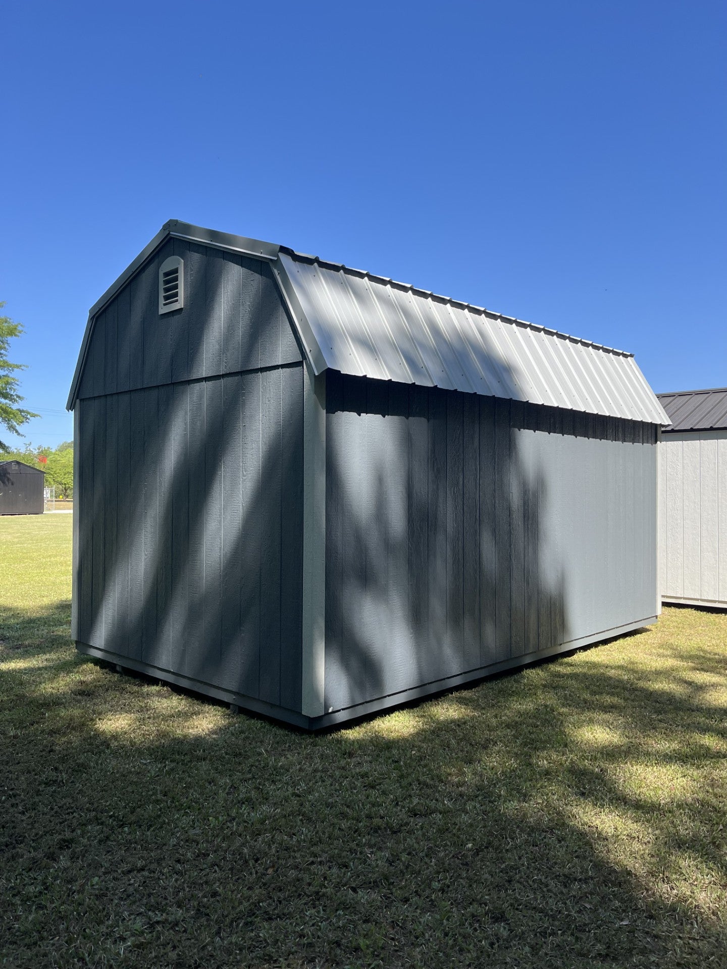 Outland Trailers 10x16 side lofted barn shed with side loft and traditional barn design, shown with wooden exterior and double doors.