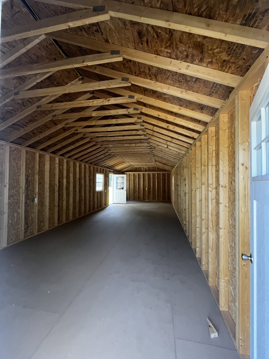 Outland Trailers 14x40 tiny home shell showing the wooden frame, exterior walls, and construction details of the tiny house.