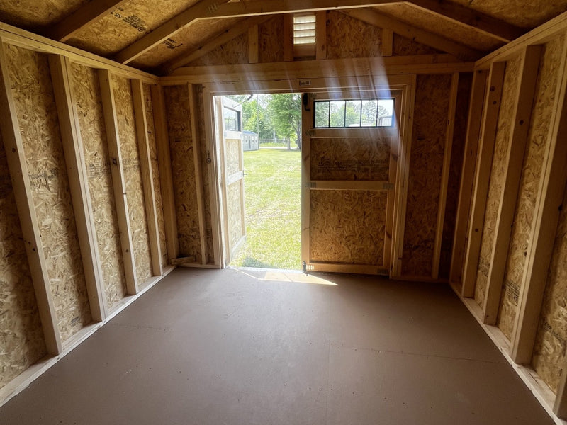 Outland Trailers 10x12 utility shed with sturdy metal walls and double doors, ideal for storage and outdoor organization.