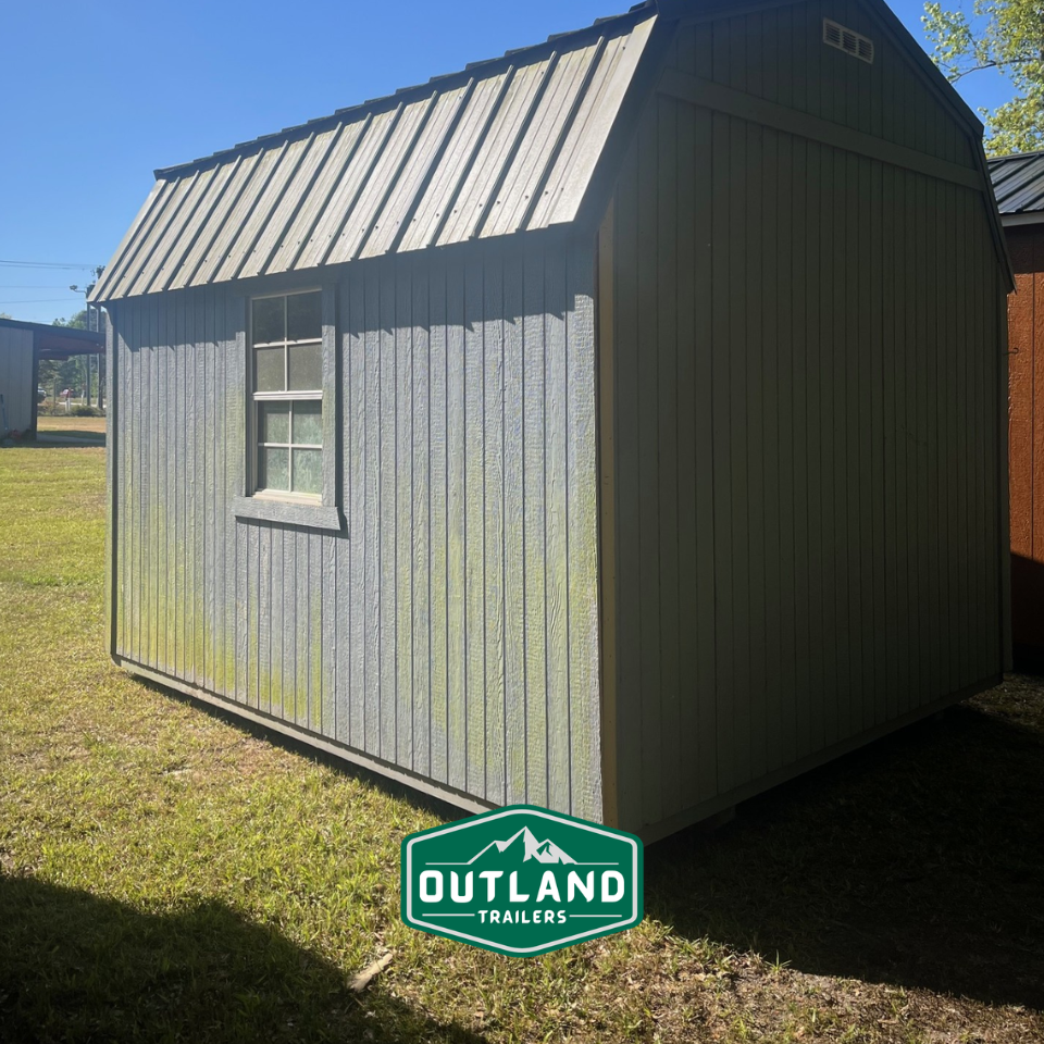 Used Outland Trailers 10x12 lofted barn with pitched roof, wooden siding, and double doors, shown in a side view.