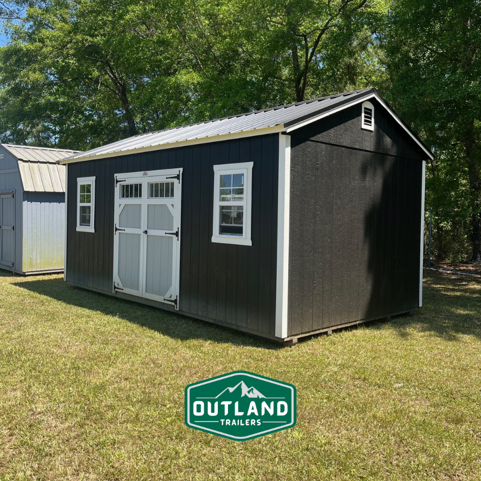 Used Outland Trailers 12x20 utility shed with metal walls and door, ideal for storage or workshop use.