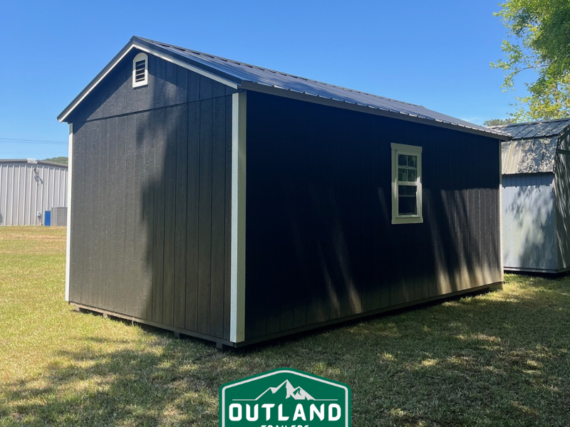 Used Outland Trailers 12x20 utility shed with metal siding and double doors, suitable for storage or workshop use.